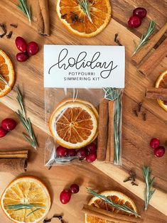 an assortment of orange slices and cinnamons on a wooden table with rosemary sprigs