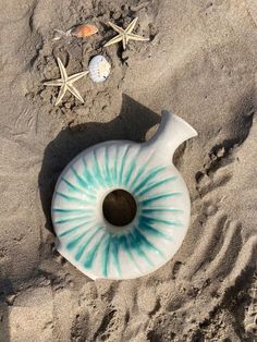 an object is laying in the sand with starfish and shells on it's side