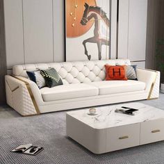 a living room with a white couch, coffee table and painting on the wall behind it