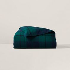 a green and black plaid blanket laying on top of a table