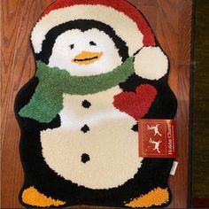 a penguin rug with a santa hat and scarf