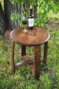 a wooden table with two wine glasses on it and a bottle of wine in the middle