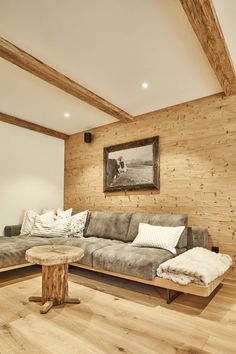 a living room filled with furniture and wooden walls next to a painting on the wall