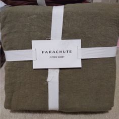 a green pillow with a white ribbon around it and a tag that says parachute on it