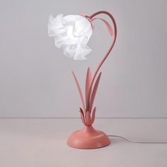 a pink table lamp with a white flower on it