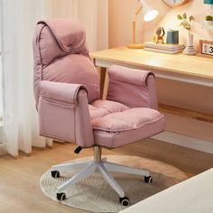 a pink office chair sitting on top of a wooden floor next to a desk with a clock above it