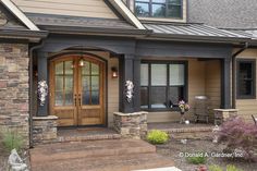 the front entrance of a house with stone pillars and steps leading up to it's door