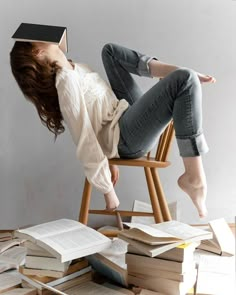 a woman is sitting on a chair with books in front of her head and she's upside down