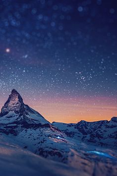 the night sky is lit up with stars above snow - capped mountains and snowy slopes