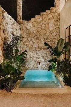 an outdoor swimming pool surrounded by plants and rocks