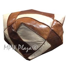 a large brown and white leather bag sitting on top of a table