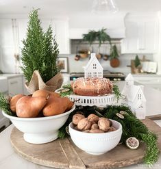 two white bowls filled with food sitting on top of a wooden tray in a kitchen