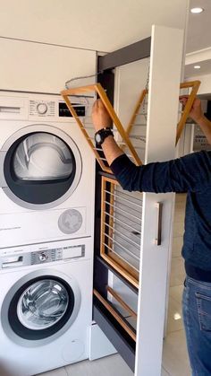 a man standing in front of a washer and dryer