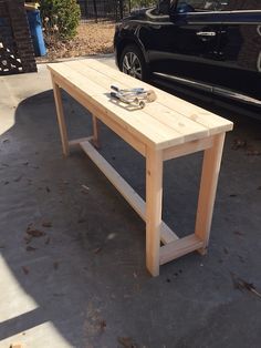 a wooden table sitting next to a parked car