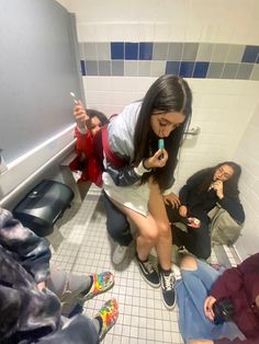 a group of people sitting in a bathroom next to each other