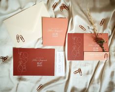 the wedding stationery is laid out on the bed