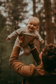 Photograph in the woods of a dad holding up their baby above their head and the baby smiling towards the camera. Family Pictures In Forest, Fall Forest Photoshoot Family, Family Photo With Newborn Outdoor, Outdoor Family Photos Christmas, Fall Family Photos Infant, Family Photos Woods Outdoor, Forest Family Photoshoot Summer, Family Pictures Park, Baby Forest Photoshoot