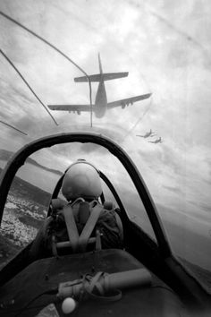 an air plane flying over the ocean with another plane in the background