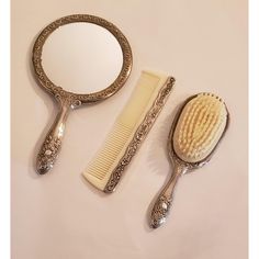 two combs and a mirror sitting on a table next to each other, one with a hair brush