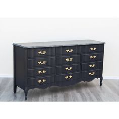 a black dresser with gold handles and drawers