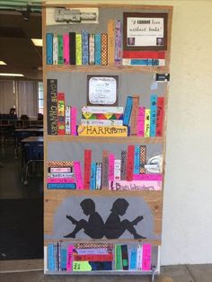 a bookshelf made out of cardboard with children's silhouettes on it