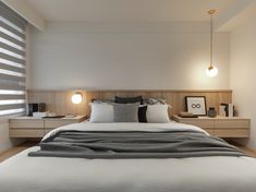 a large bed sitting under two lamps in a bedroom