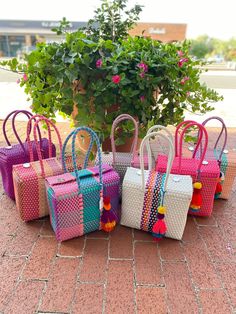 "This beautiful basket bag is made with recycled PVC, handwoven by Mexican artisans. Each bag is one of a kind with a unique design and color pattern. *Includes Pompom tassel *Rinsable *Durable *Fashionable *Light Weight *Eco- Friendly *Reusable Closes at top with four flaps and two magnetic buttons. *All bags are handmade, measurements will vary slightly. Length x Width x Height / Strap Drop Small Basket Bag: 10\" x 5\" x 8\"/ 8 inches"