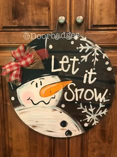 a door hanger that says let it snow with a snowman on the front