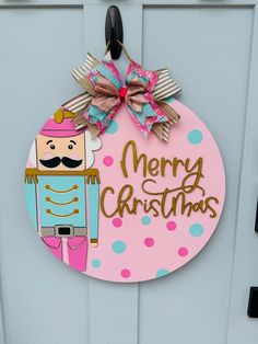 Nutcracker obsessed? We are too! We offer this door hanger in both traditional Christmas colors and a beautiful whimsical pink and turquoise. Most items are made to order, so please allow two weeks for us to create your item especially for you. Bow fabric may vary slightly from the photo. Wooden Cutout Door Hangers, Painted Round Door Hangers, Painted Door Hanger Ideas, New Year Door Hanger, Round Door Hanger Ideas, Nutcracker Door Hanger, Valentine Door Hanger Wooden, Circle Door Hangers Wooden Diy, Round Wooden Door Hangers