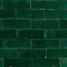 a green brick wall that is very close to the ground