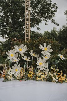 flowers are arranged in front of a tall tower