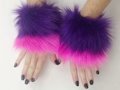 a pair of purple and pink furry gloves with black nail polish on the fingers,