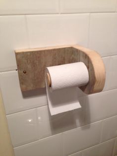 a wooden toilet paper holder on the wall