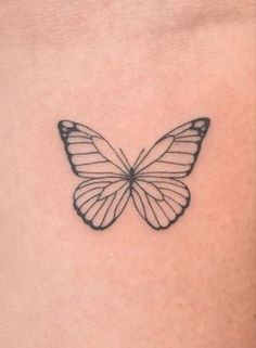 a black and white butterfly tattoo on the back of a woman's stomach,