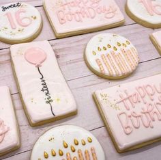 decorated birthday cookies on a table with pink icing