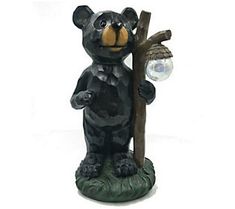 a statue of a bear holding a tree branch