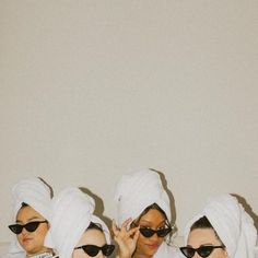 three women in white robes and sunglasses on their heads