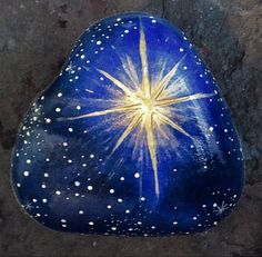 a blue rock with white dots and a yellow star painted on the top is shown