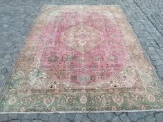 an old rug is laying on the ground in front of a brick sidewalk with cobblestones