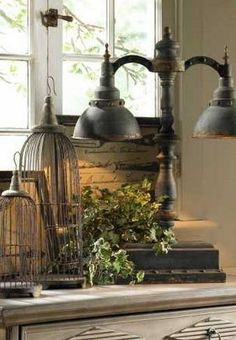 an antique dresser with birdcages and lamps on top