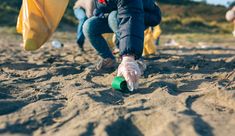 several people are digging in the sand with shovels and other things on the ground