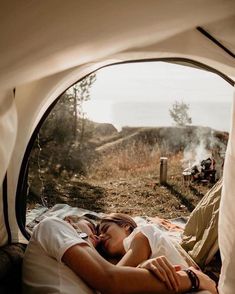 a man and woman are sleeping in a tent