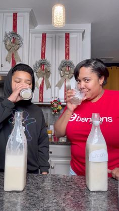 two people are drinking milk in the kitchen