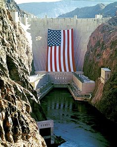 an american flag hanging on the side of a dam