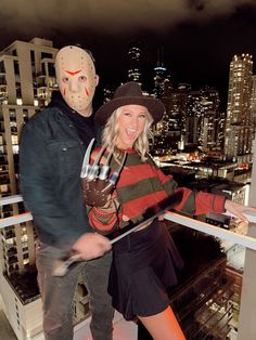 a man and woman dressed up as slash and friday the 13th in front of a cityscape