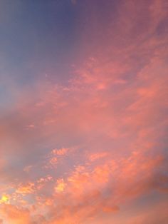 an airplane is flying in the sky with pink and blue clouds behind it at sunset