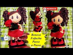 the doll is wearing a red dress and holding a flower in her hand, while standing on a green checkered tablecloth