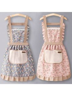 two children's aprons with flowers on them, one is pink and the other is blue