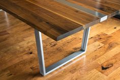 a wooden table sitting on top of a hard wood floor next to a metal frame