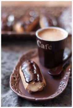 a cup of coffee next to a half eaten pastry